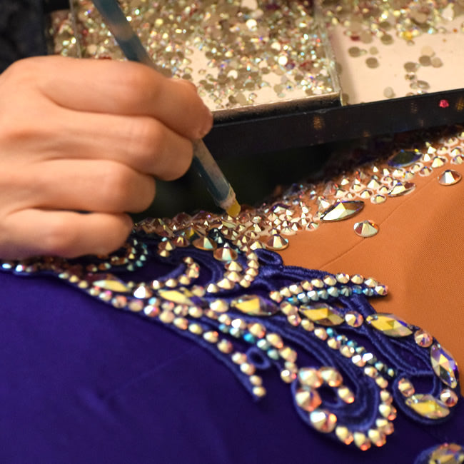 Designer decorating dress with crystals 