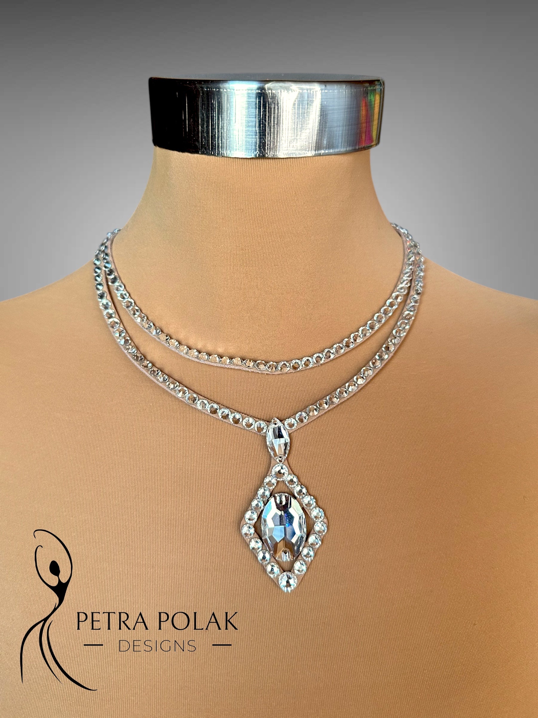Silver necklace with a pendant on a mannequin bust, branded 'Petra Polak Designs'.