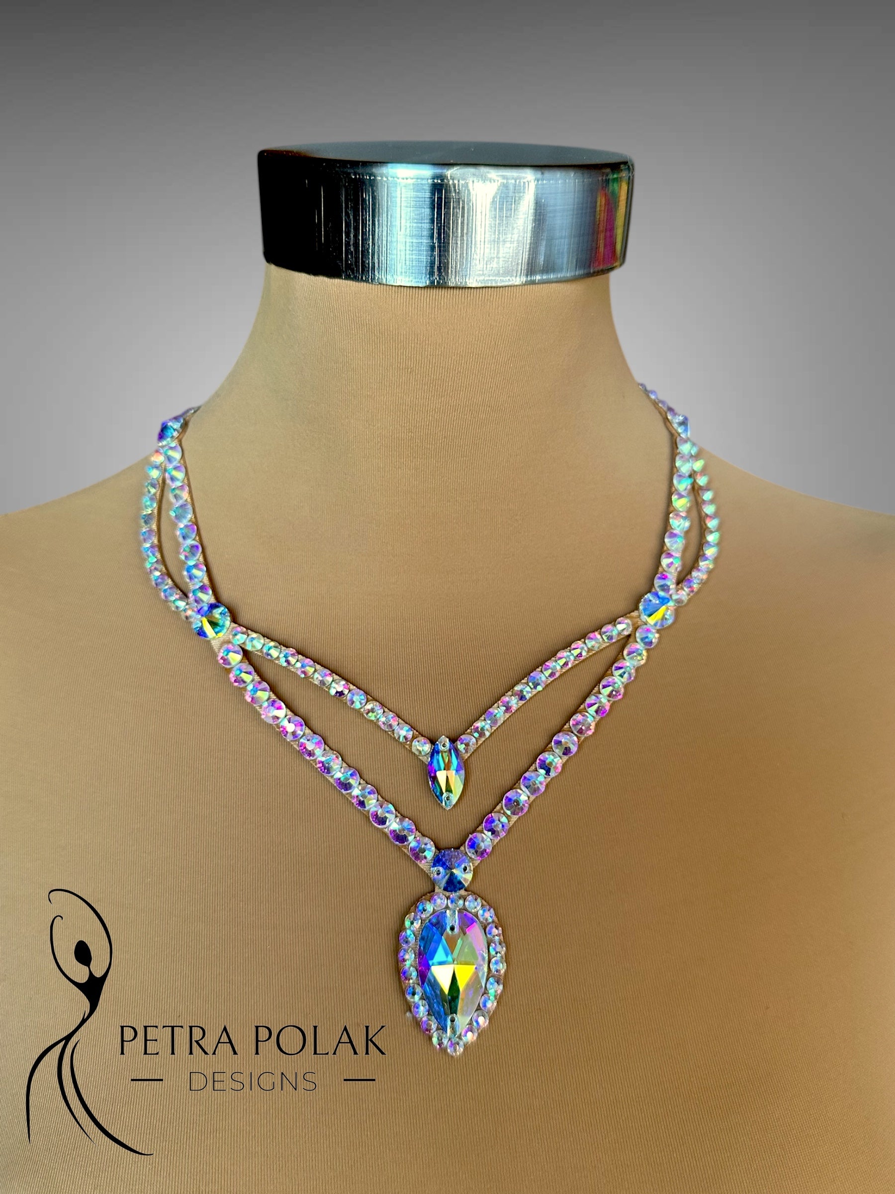 Multicolored beaded necklace on a mannequin with 'Petra Polak Designs' branding.