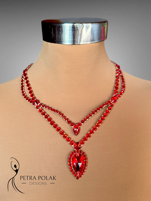 Red beaded necklace on a mannequin with 'Petra Polak Designs' branding.