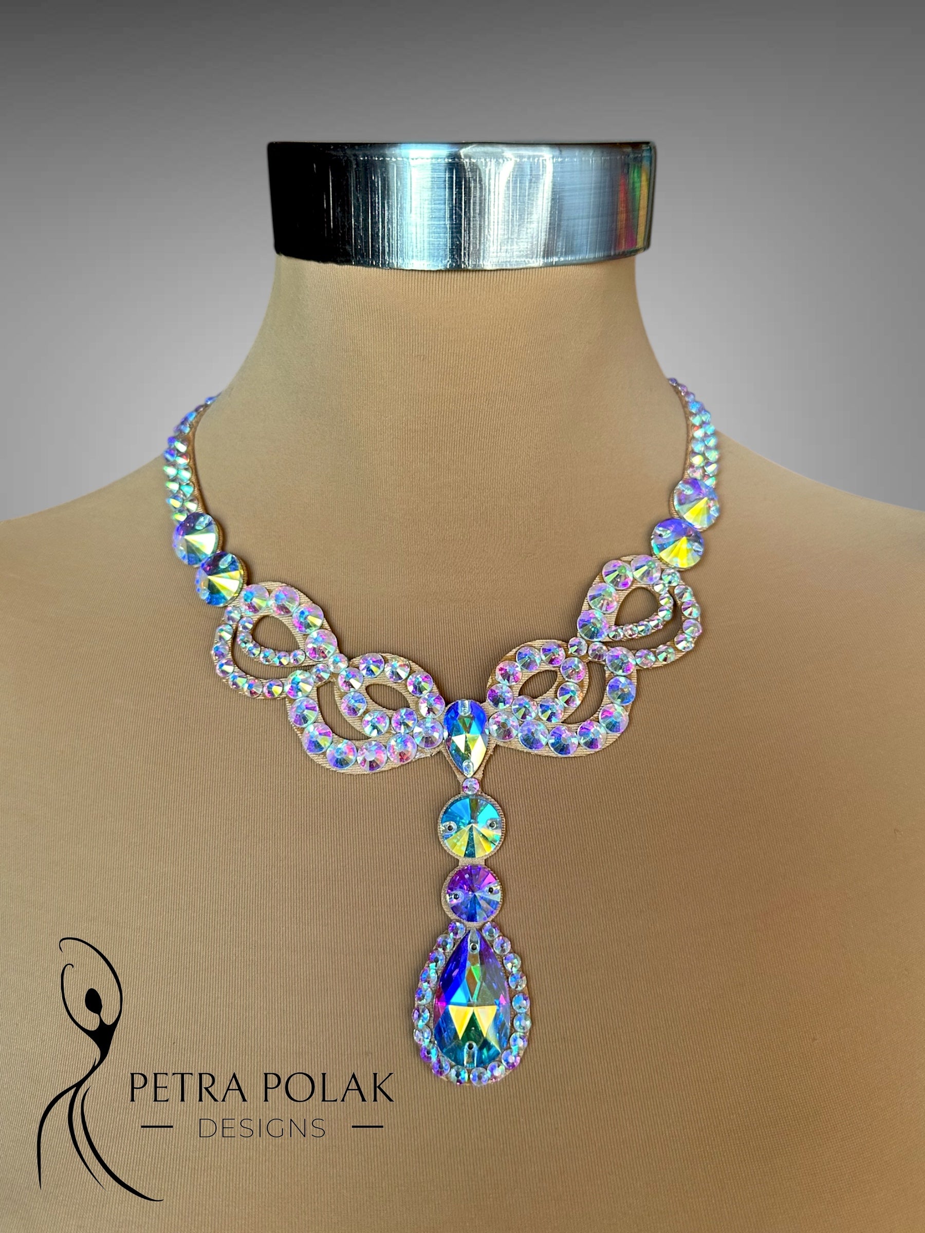 Elegant necklace with multicolored crystals on a mannequin bust, branded 'Petra Polak Designs'.