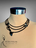 Mannequin wearing a silver headband and black beaded necklace with 'Petra Polak Designs' branding.