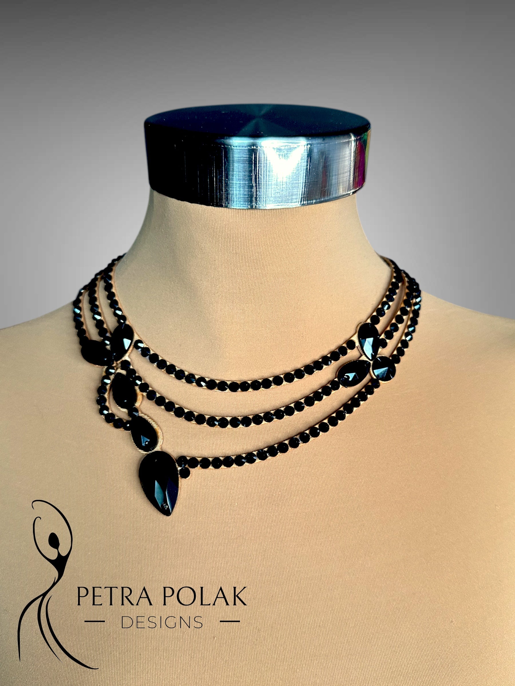 Mannequin wearing a silver headband and black beaded necklace with 'Petra Polak Designs' branding.