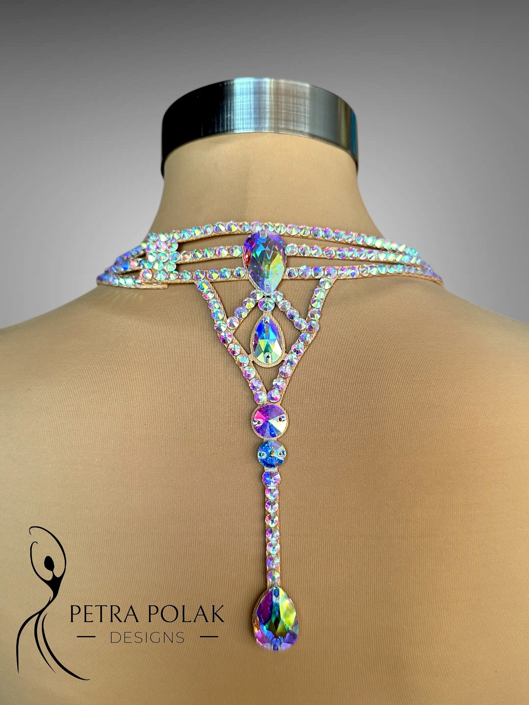 Multicolored gemstone backpiece on a mannequin with 'Petra Polak Designs' branding.