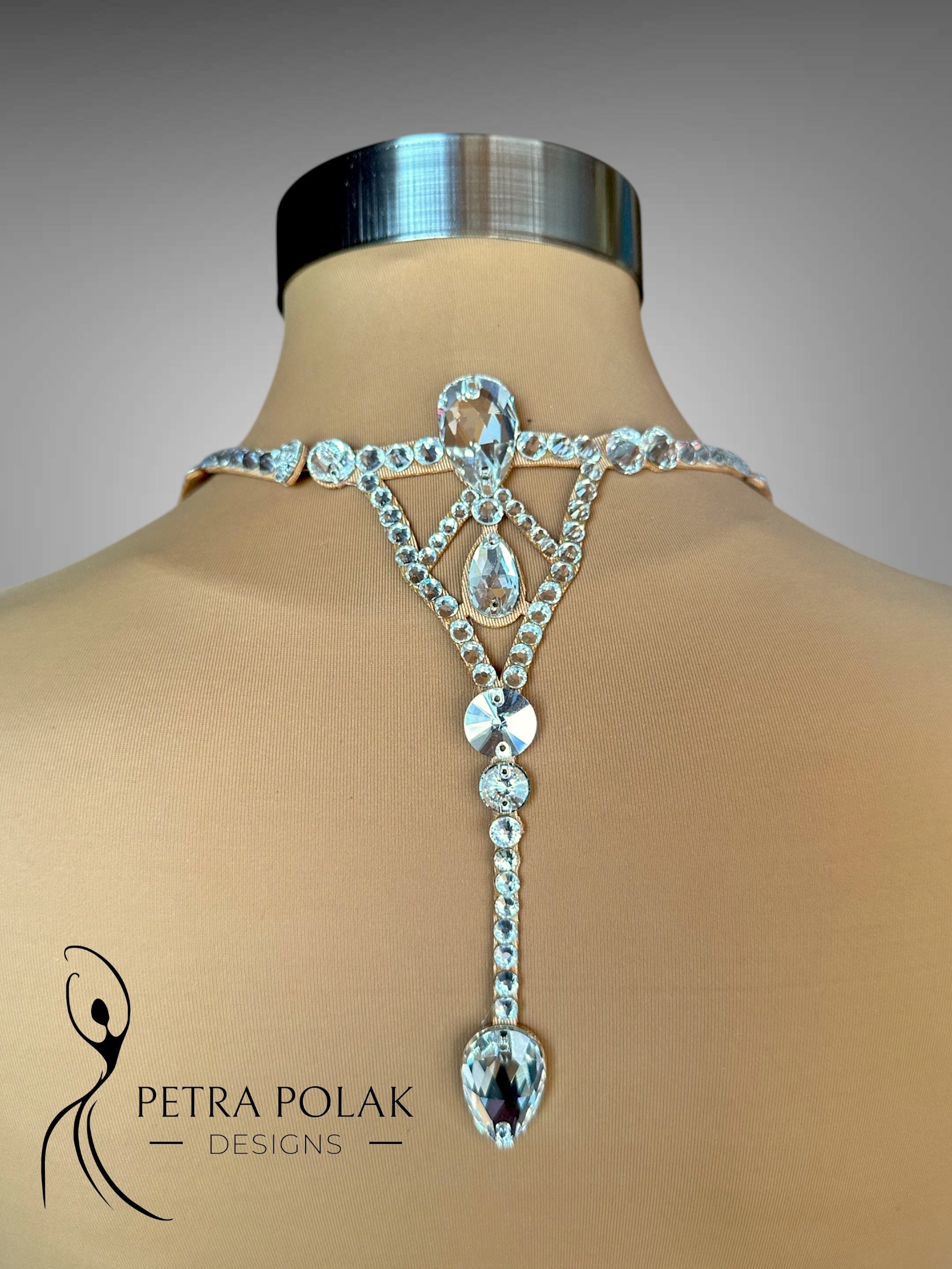 Elaborate silver back jewelry piece on a mannequin with 'Petra Polak Designs' branding.