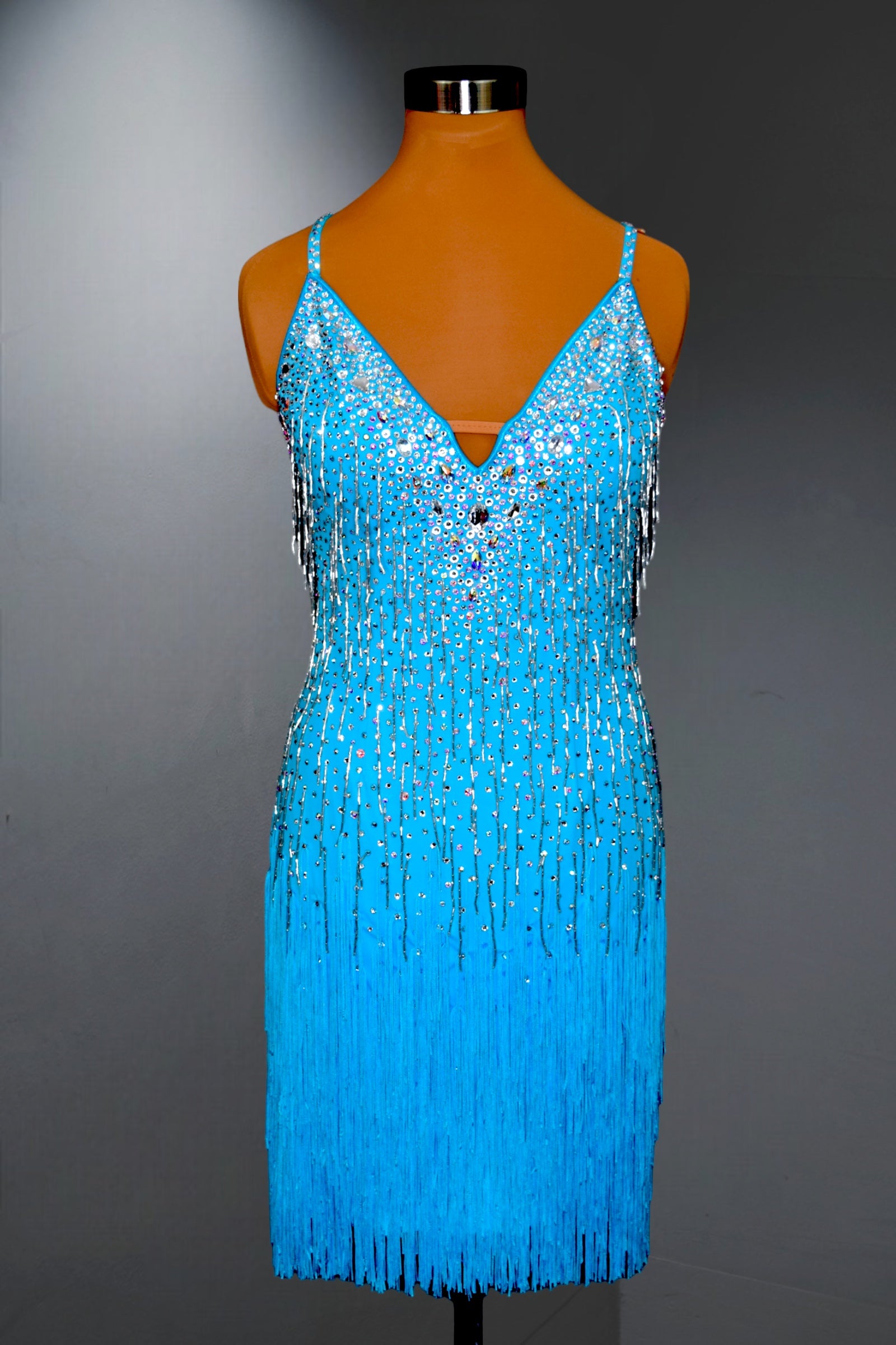 Blue beaded dress on a mannequin against a gray background