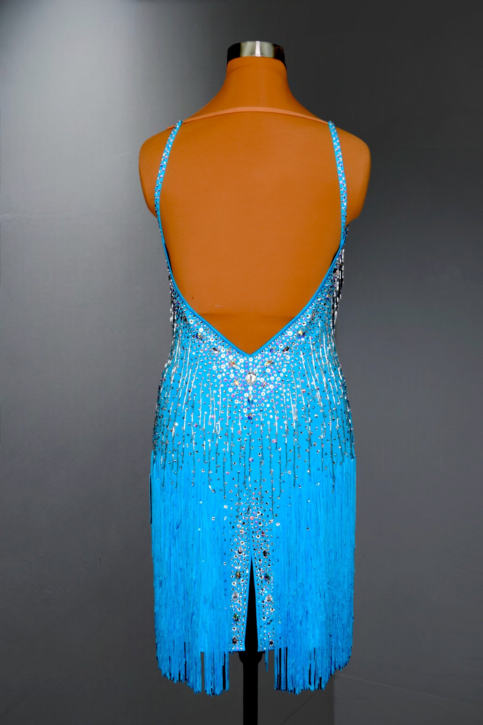 Blue fringe dress on a mannequin against a gray background