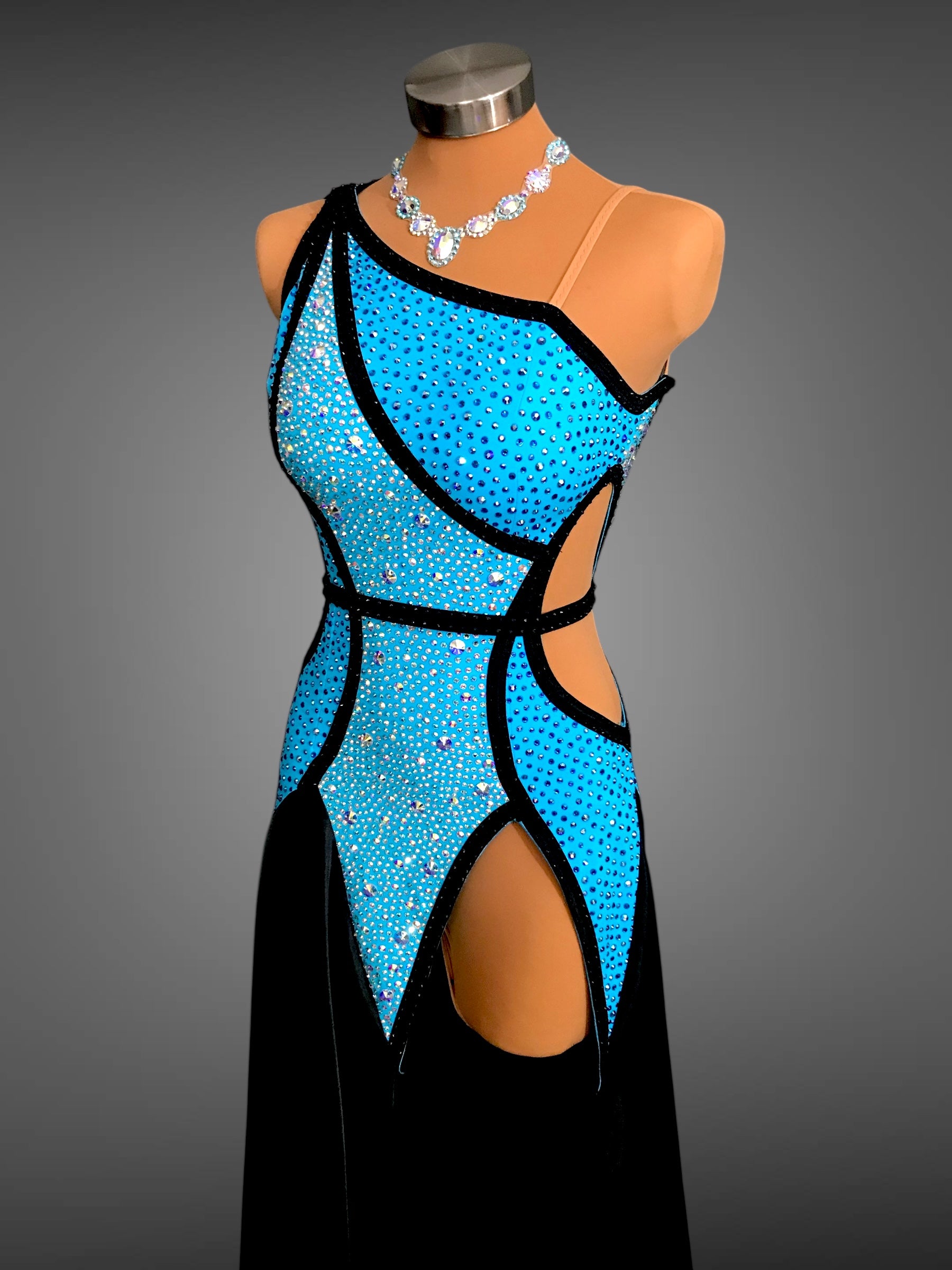 Mannequin wearing a blue and black dress with cut-out design on a gray background