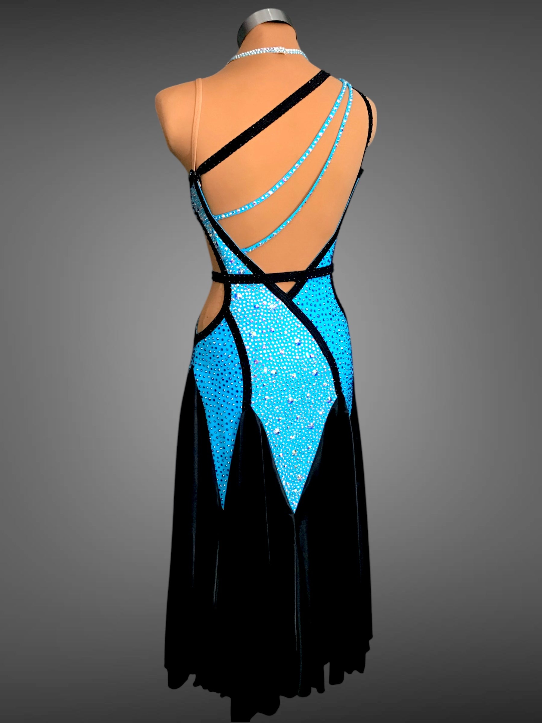 Black dress with blue embellishments on a mannequin against a gray background