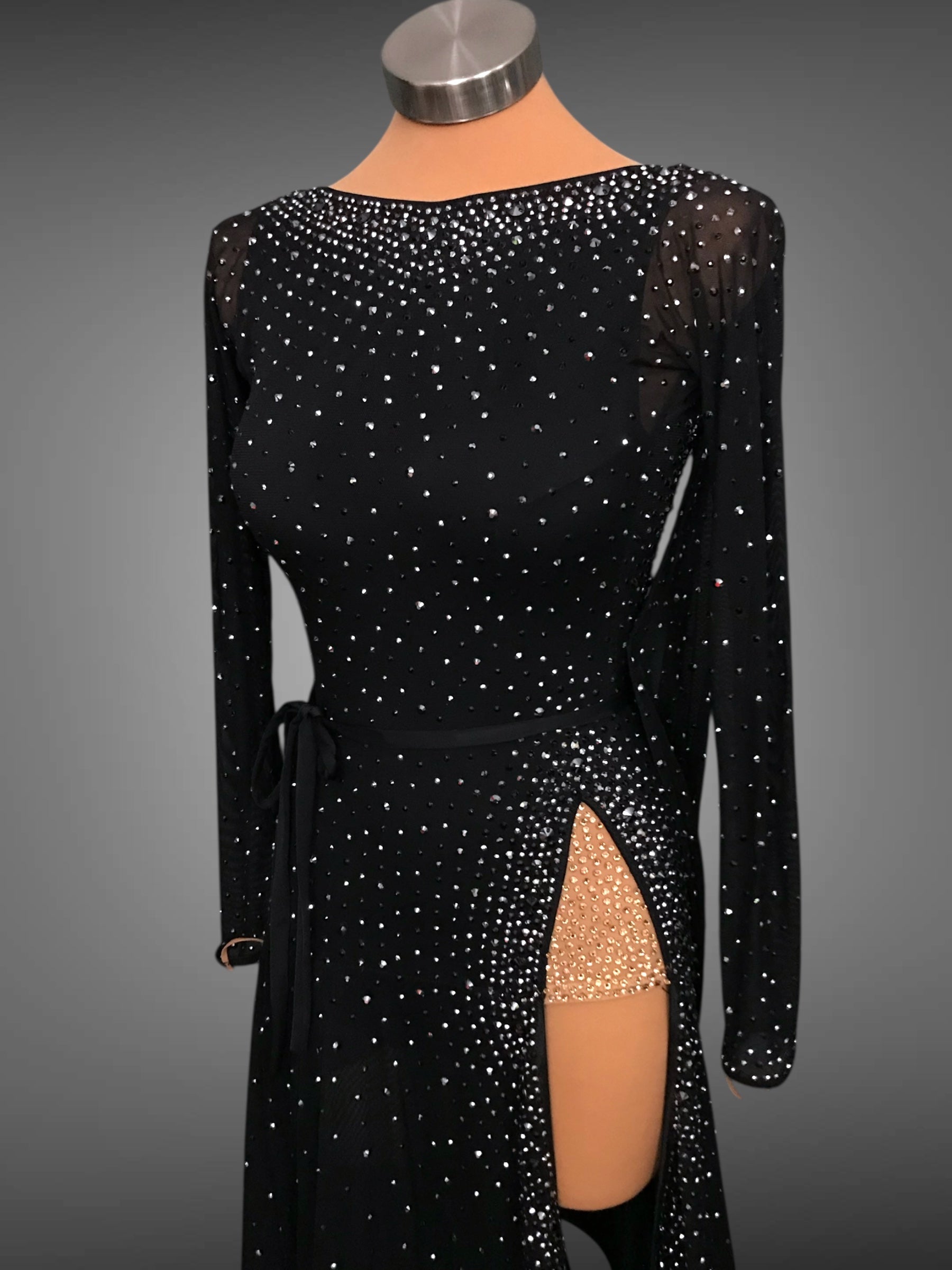 Black dress with sequin detailing on a mannequin against a gray background