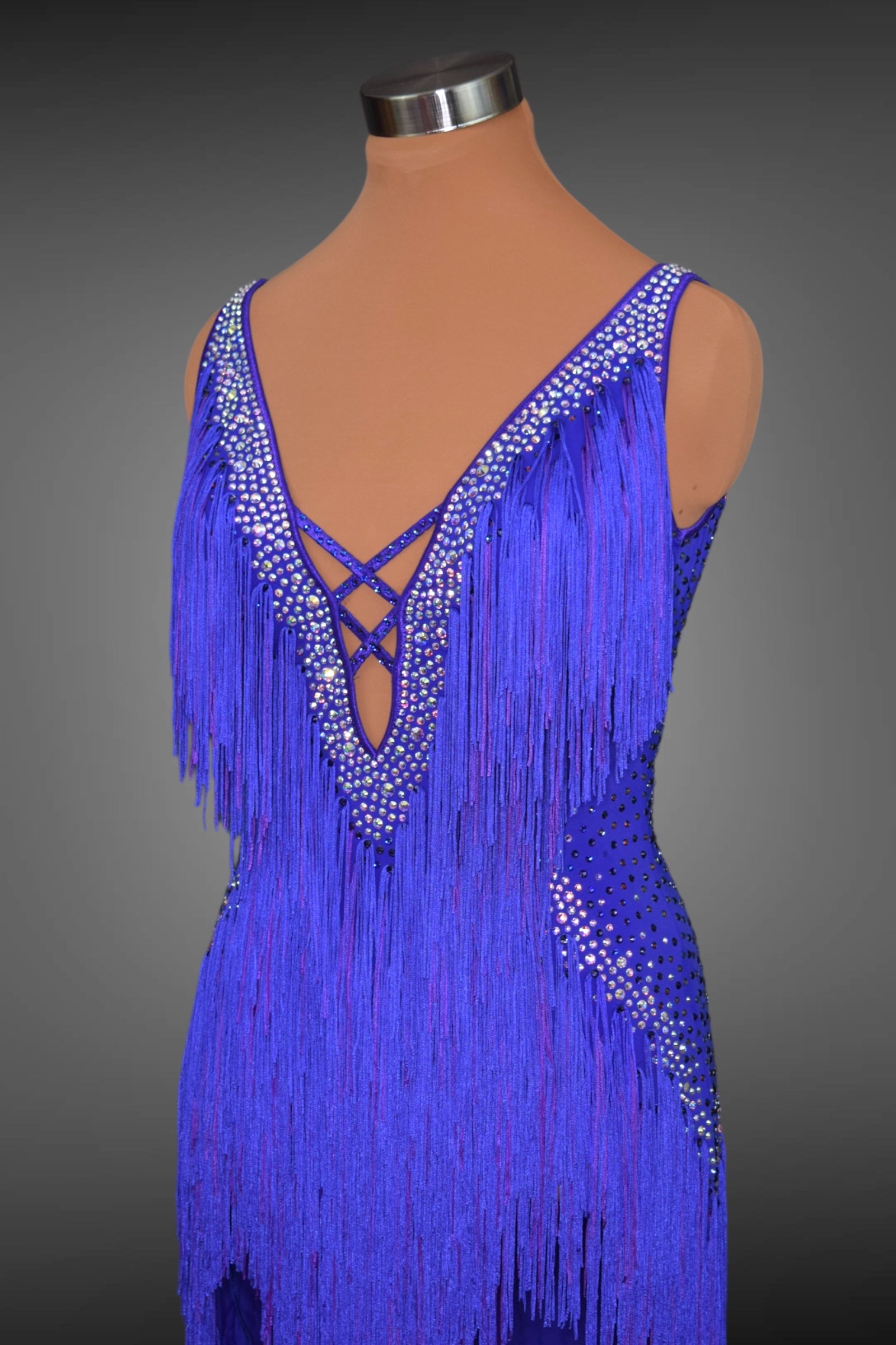 Blue fringe dress on a mannequin against a gray background