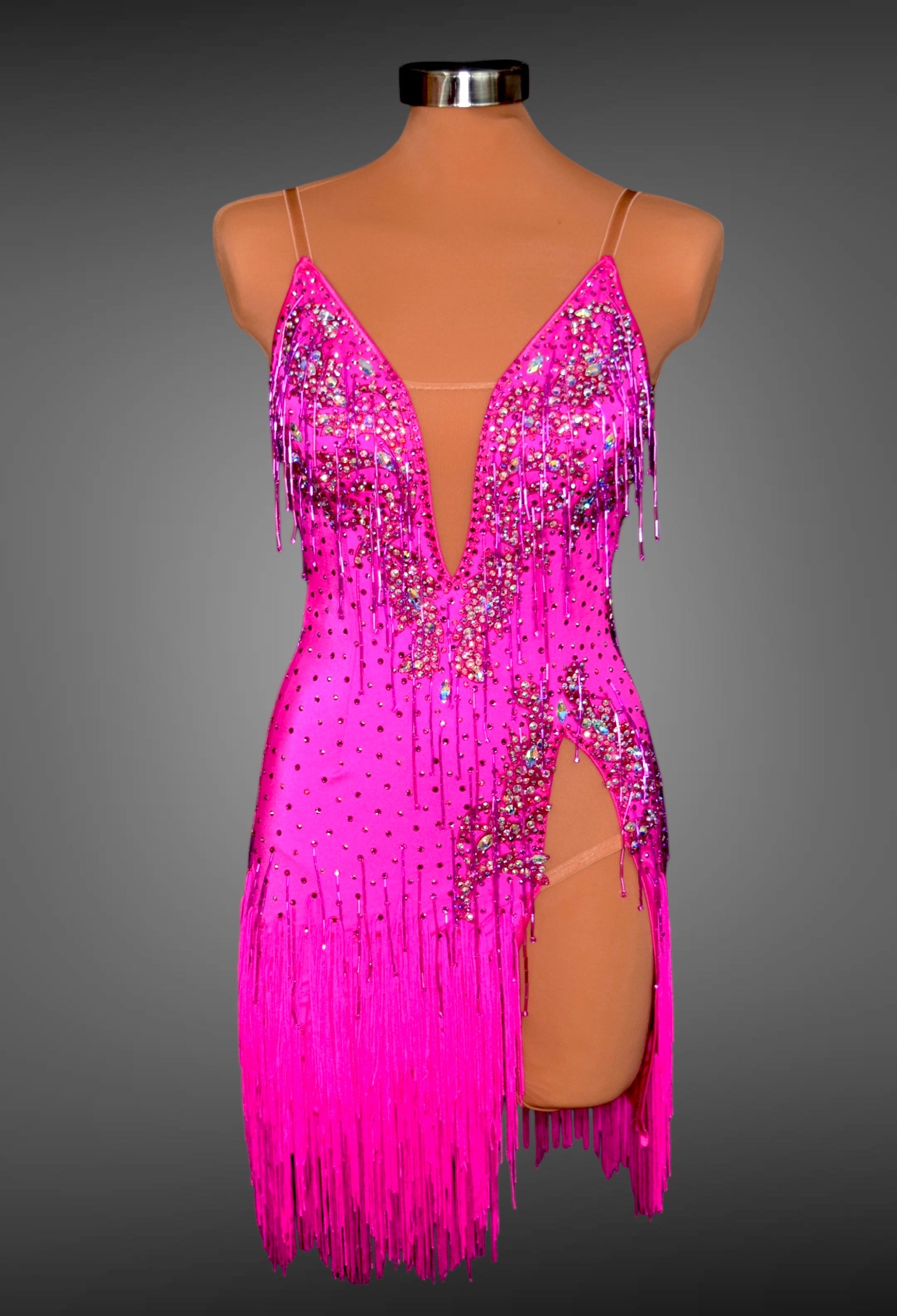 Pink fringe dress with sequins on a mannequin against a gray background