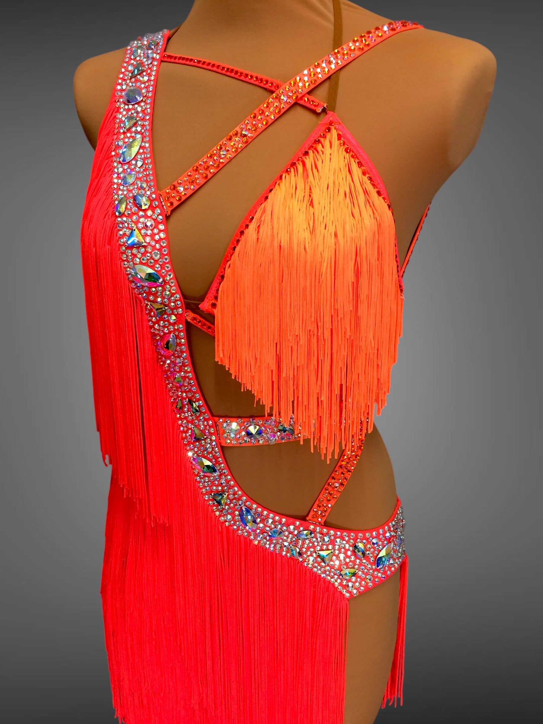 Red fringe dress with embellishments on a mannequin against a gray background