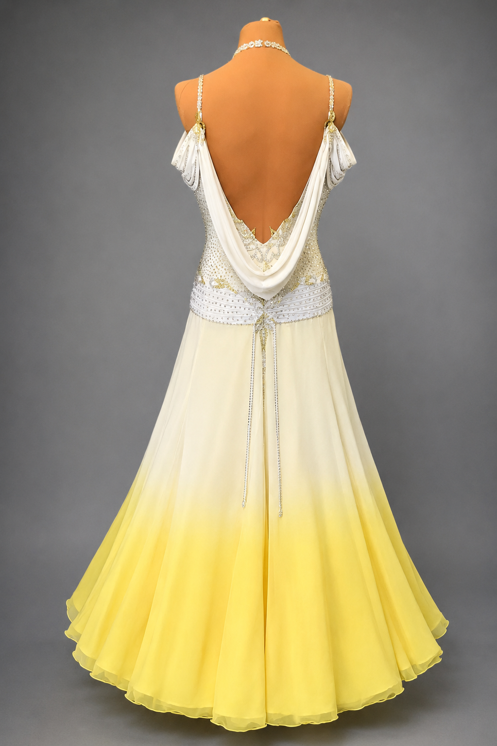 Yellow and white dress on a mannequin against a gray background