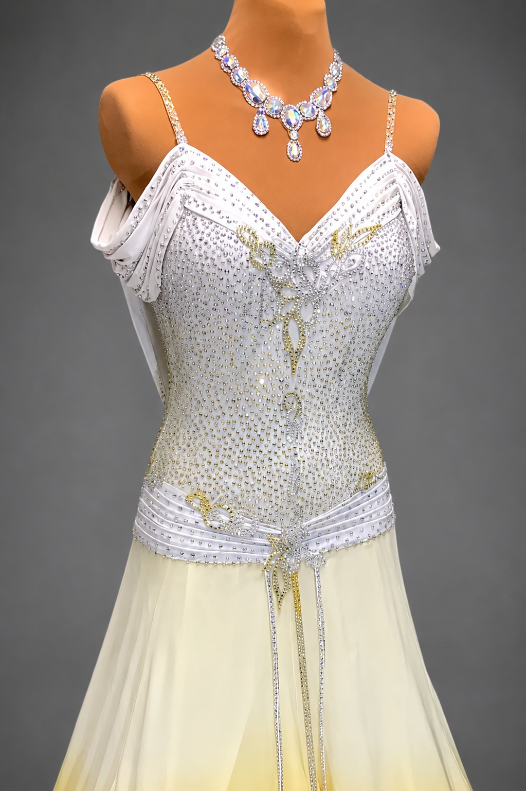 Mannequin wearing a white beaded dress with a necklace on a gray background