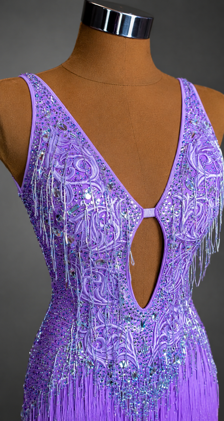Purple beaded dress on a mannequin against a gray background