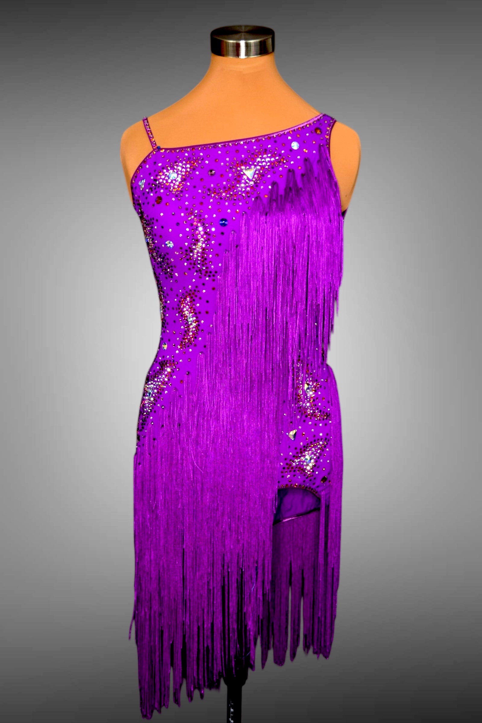 Purple fringe dress with sequins on a mannequin against a gray background