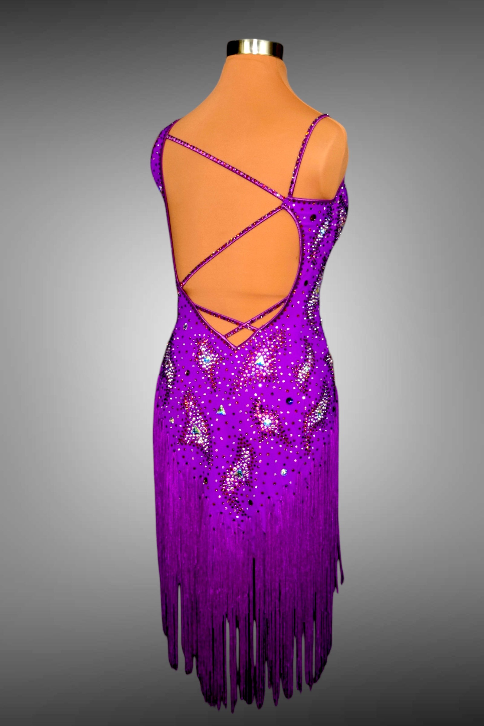 Purple fringe dress on a mannequin against a gray background