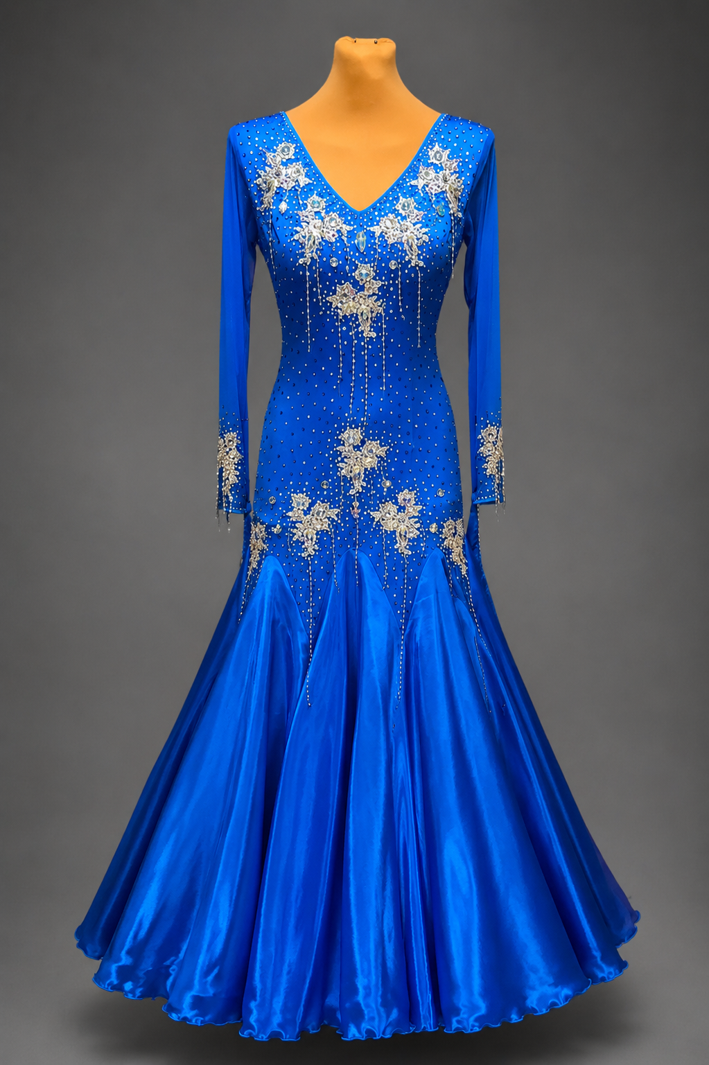 Blue ballroom dance dress with floral embellishments on a gray background