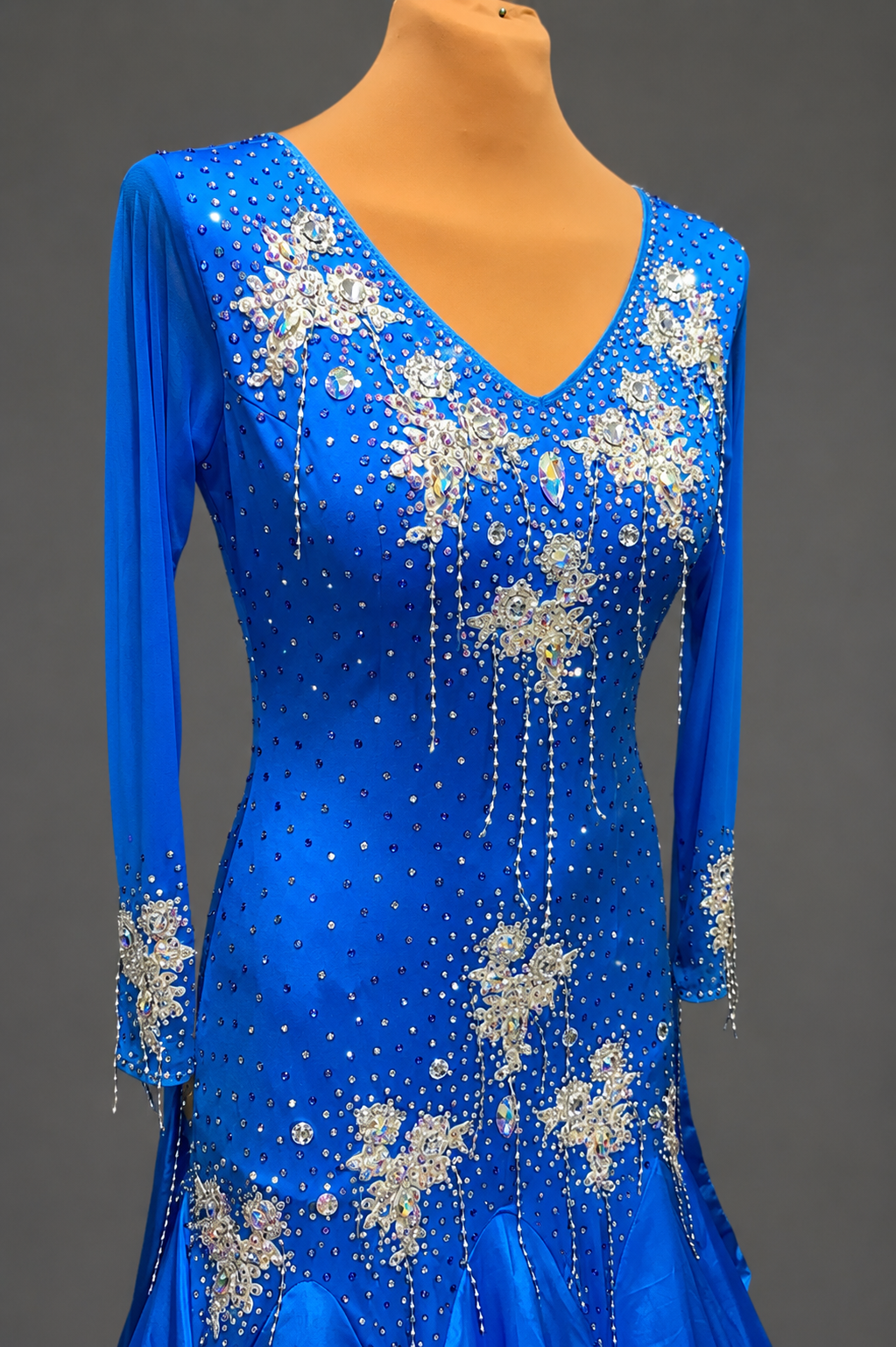 Blue dress with silver floral embellishments on a mannequin against a gray background