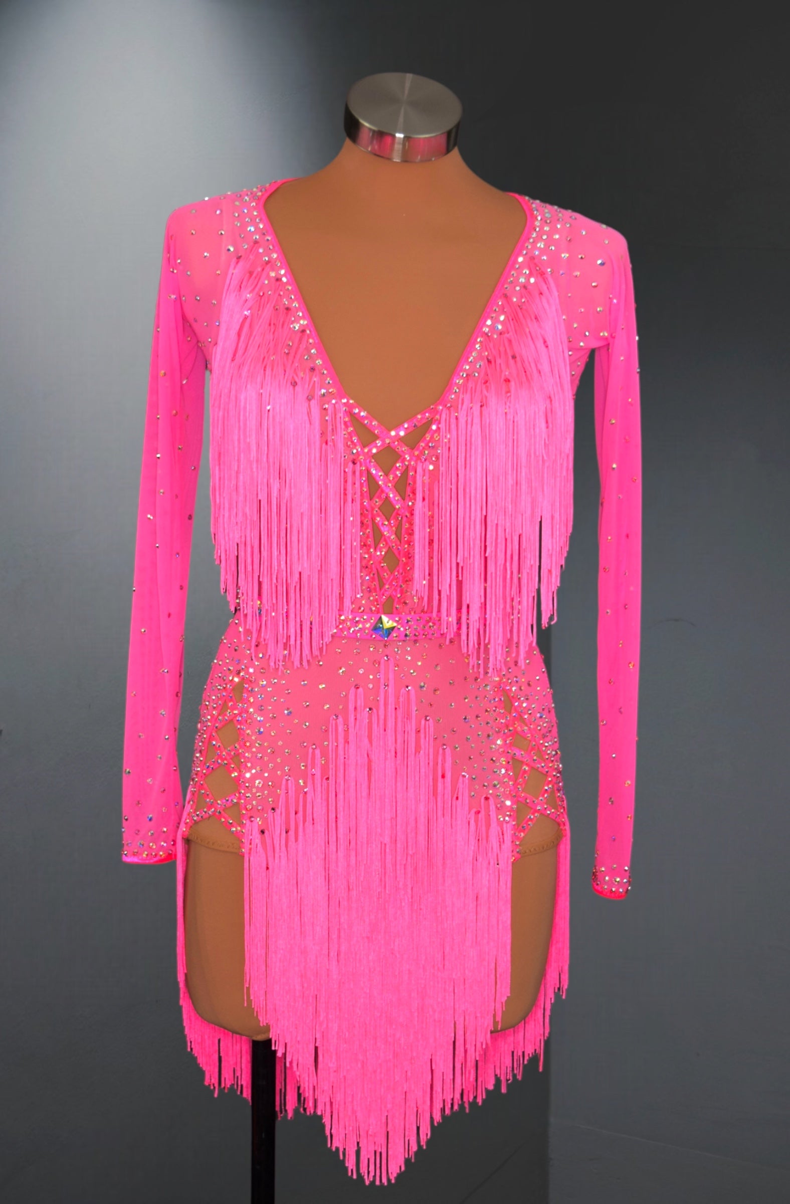 Pink fringe dress on a mannequin against a dark background
