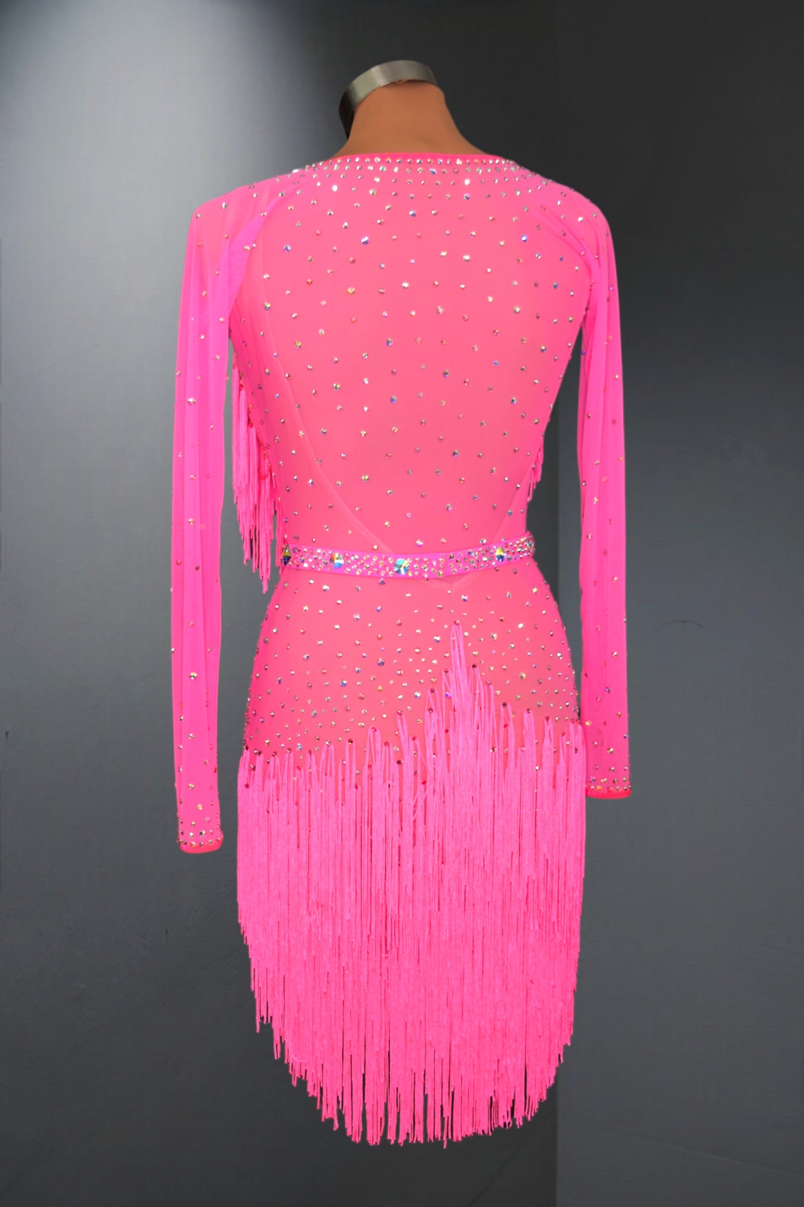 Pink dress with fringe and beading on a mannequin against a dark background