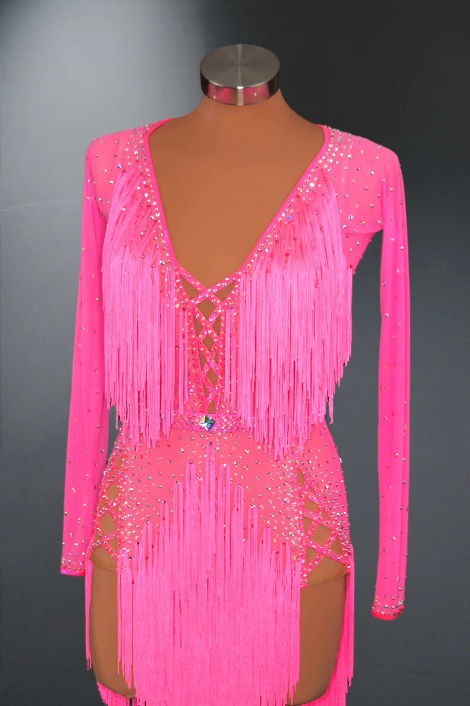 Pink fringe dress on a mannequin against a dark background