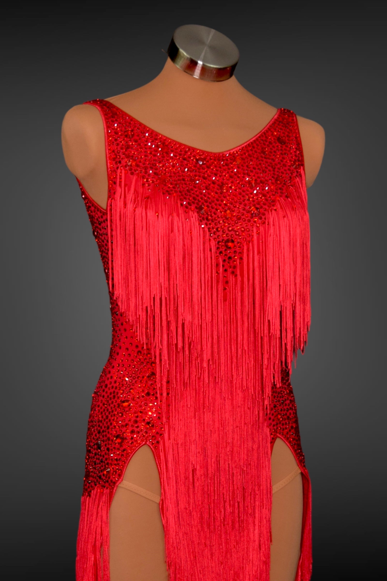 Red fringe dress with sequin details on a mannequin against a dark background
