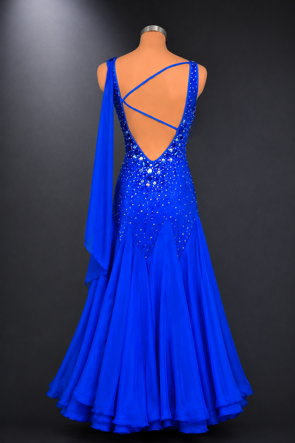 Blue evening gown with open back on a mannequin against a dark background