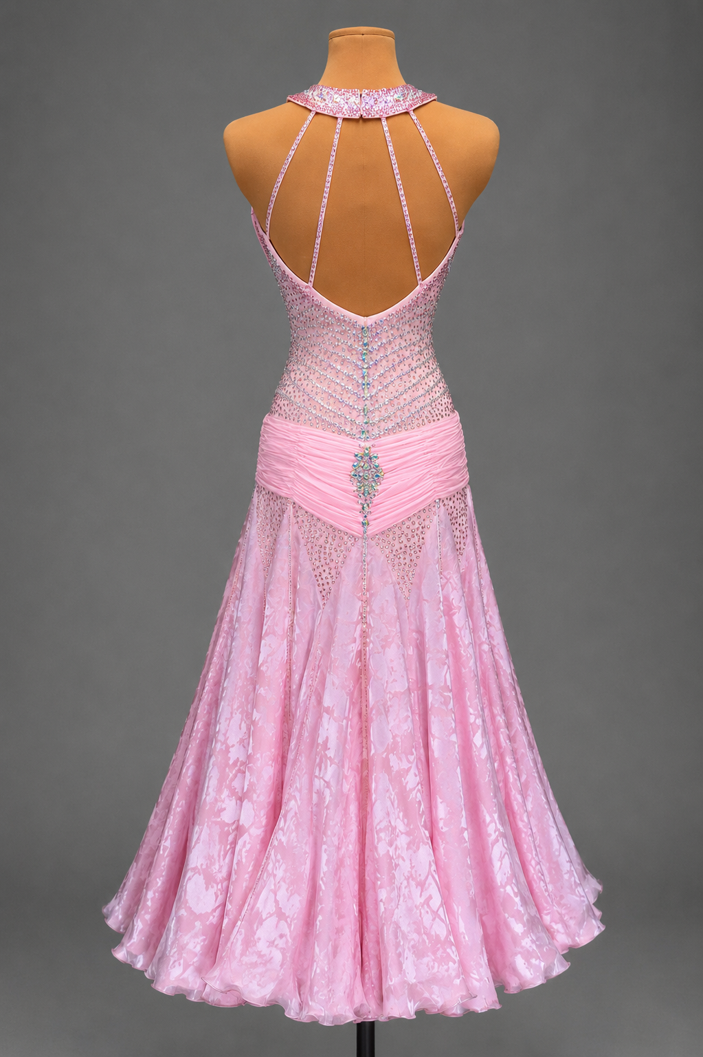 Pink dress with intricate detailing on a mannequin against a gray background