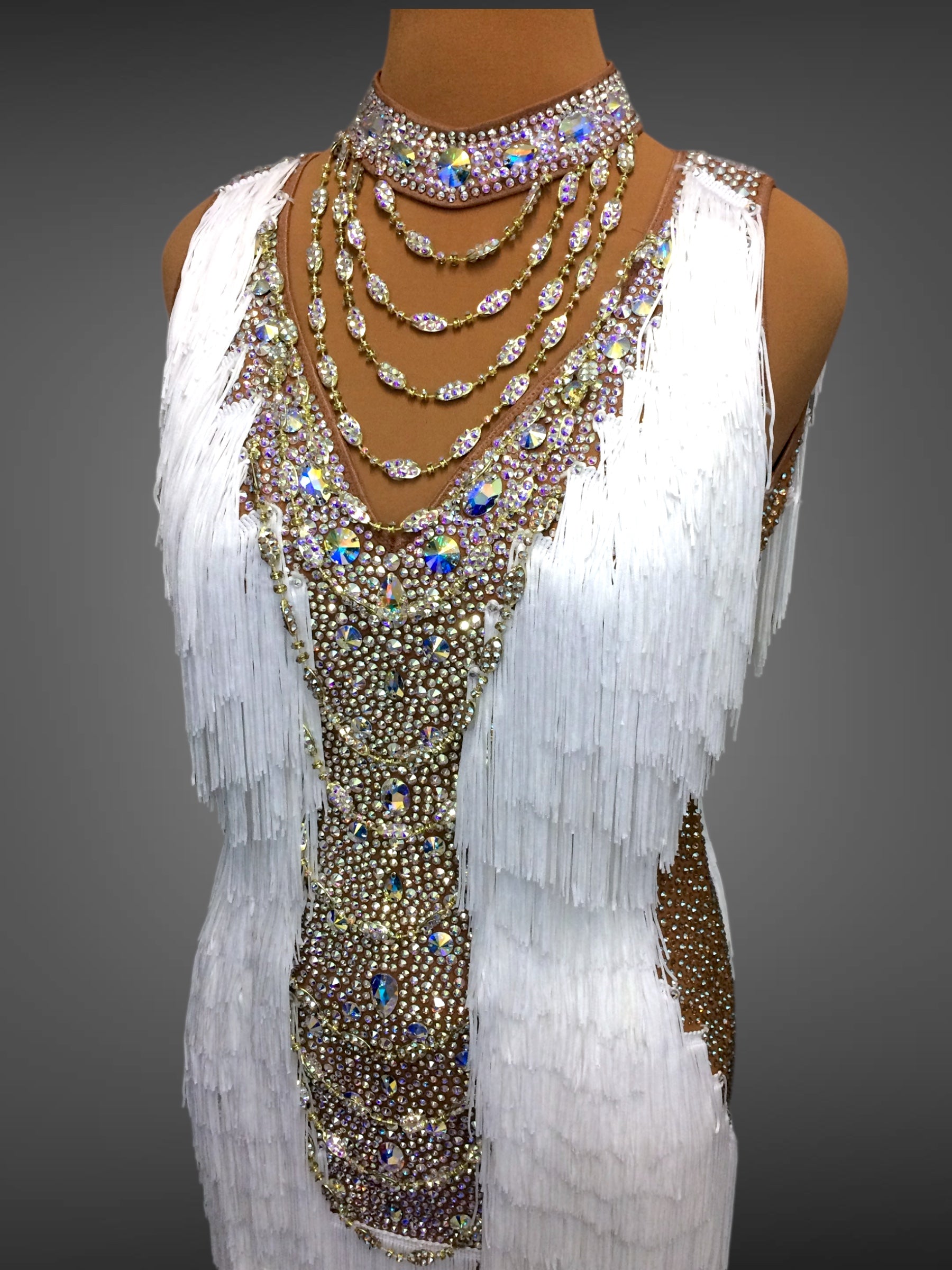 Decorative dress with beads and fringes on a mannequin against a gray background